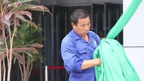 Workman ties up some cloth at an event Vídeos de archivo 75893419