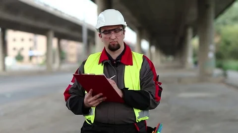 Workman under overpass makes notes Stock Footage 82916540