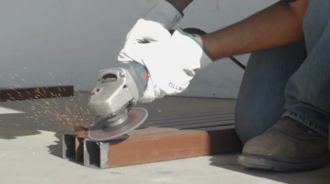 Workman using angle grinder outside industrial hangar Stock Footage 56863732