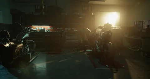 Workman using compressor on motorcycle in garage Stock Footage 265009071