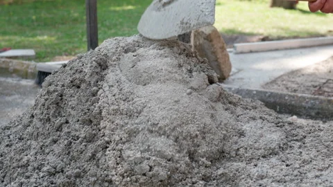 Workman using metal shovel for mixing wet concrete, builder preparing mortar Stock Footage 162763702