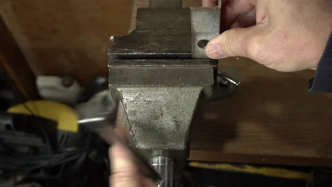 A workman using a vise to clamp a piece of steel in a workshop Stock Footage 236574435