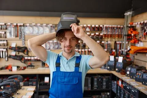 Workman wearing protective plastic welding mask at hardware store Stock Photos