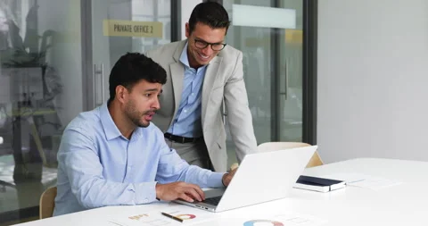 Workmates engaged in teamwork using laptop in conference room Stock Footage 315550443