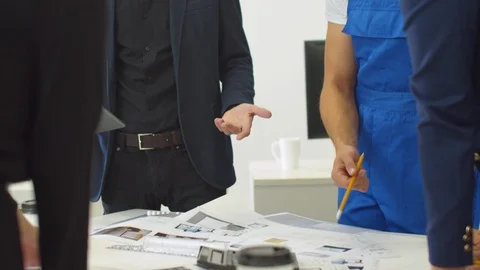 Workmates stand and discuss schemes of houses in the office Stock Footage 121807951