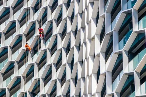 Workmen absailing down a tall building Stock Photos