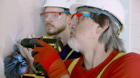 Workmen install plasterboard drywall at construction site Stock Footage 133634693