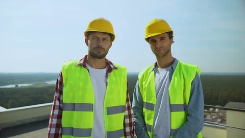 Workmen looking camera standing rooftop outdoors, construction industry, job 動画素材 117217580