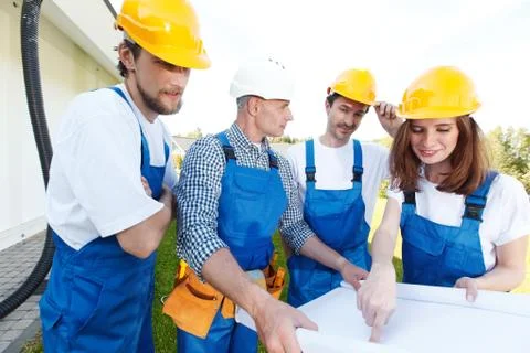 Workmen looking at house design Stock Photos