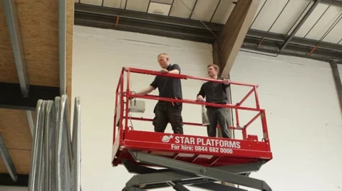 Workmen operate lifting platform in construction site Stock Footage 63146766