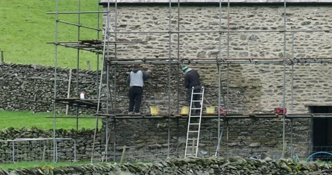 Workmen rendering a barn conversion in Austwick, Yorkshire Dales, UK. Video stock 239760286
