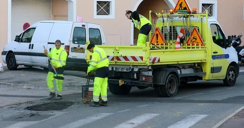 Workmen Repairing Road Surface Damaged By Weather And Traffic Use Stock Footage 99366130