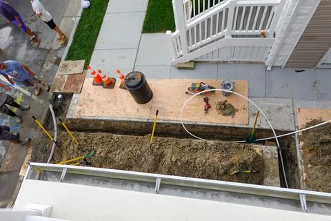 Workmen seen from above after digging a trench to replace a broken pipe in .. Stock Photos