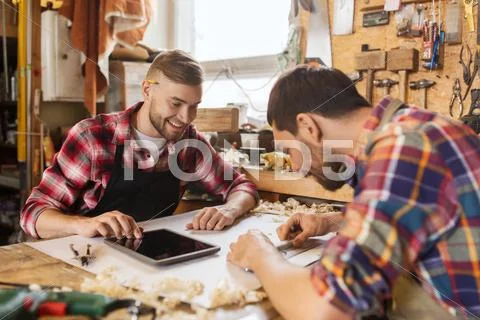 Workmen with tablet pc and blueprint at workshop Stock Photos