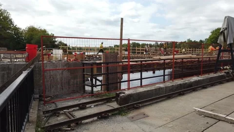 Workmen working on a bridge pan to the river Stock Footage 138650068