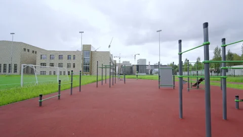 Workout area with bars and pull-up stations on red surface 库存影片 334682681