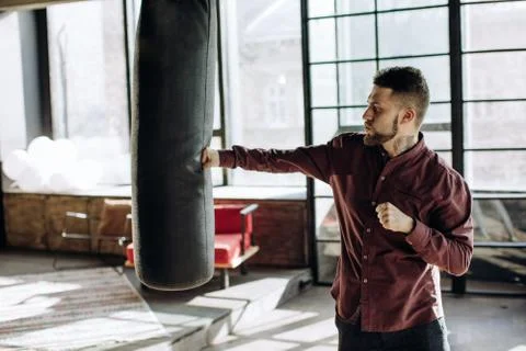 Workout during the work day. A young man is boxing in his shirt Stock Photos