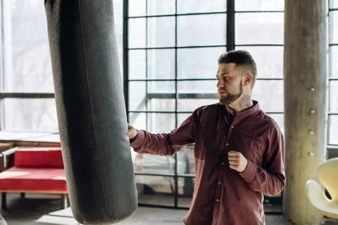 Workout during the work day. A young man is boxing in his shirt Stock Photos