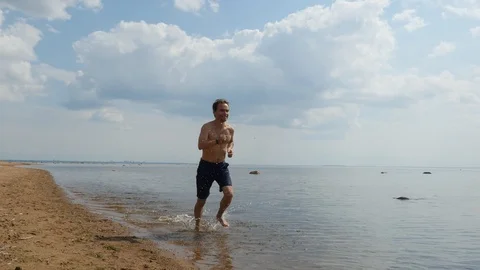 Workout of good looking guy runner on coast in sunny day Stock-Footage 93410869