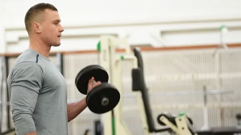 Workout at gym. Man doing exercises with dumbbell Stock Footage 152874963