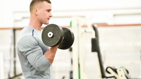 Workout at gym. Man doing exercises with dumbbell Stock Footage 152875389