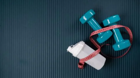 Workout kit with space for text - shaker, dumbbells, centimeter Stock Photos