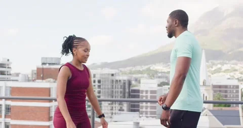 Workout partners checking watches on rooftop stepping back and warming up with Stock Footage 340751013
