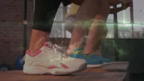 Workout partners following instructor cue, stepping with white shoes on step Stock Footage 323385192