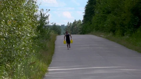 Workout on the road with jerrycans in hands Stock Footage 80436796