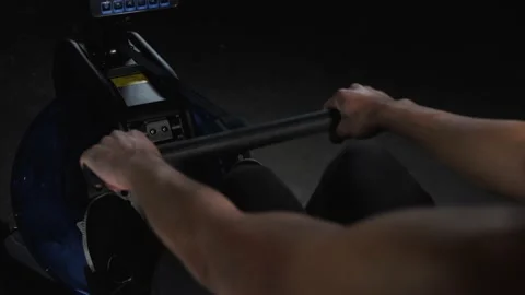 Workout on rowing machine Stockbeeldmateriaal 160041168