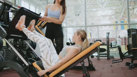 Workout session at a gym with two women using fitness equipment together Stock Footage 344887796