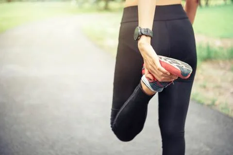 Workout wellness concept. Close up runner feet with running shoes on road in Stock Photos