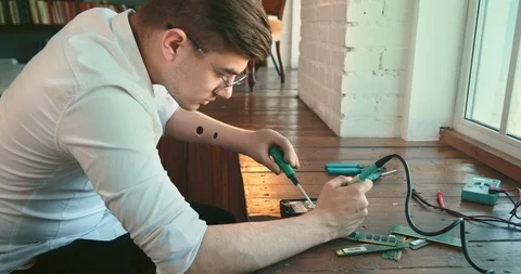 Workplace of amputee invalid. Man with artificial hand working. Soldering 4k. Stock Footage 114783655