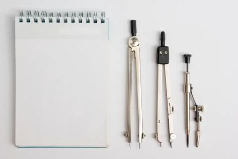 Workplace of architect - notepad and divider compass on table. Engineering tools Stock Photos