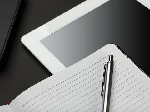 Workplace with blank digital tablet, notebook and pen on black background Stock Photos