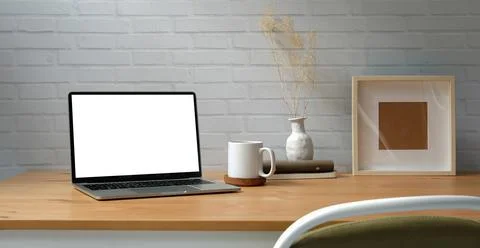 Workplace comfortable with computer laptop, coffee cup, notebook, picture fra Stock Photos