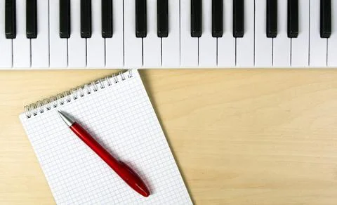 Workplace of a composer or singer. Synthesizer keyboard, notepad and pen Stock Photos