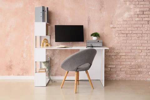 Workplace with computer and folders near grunge wall in office Stock Photos