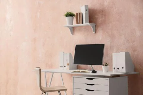 Workplace with computer and folders near grunge wall in office Stock Photos