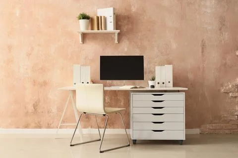Workplace with computer and folders near grunge wall in office Stock Photos