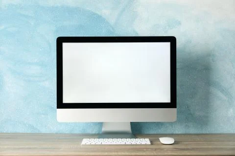 Workplace. Computer with empty screen on wooden table. Light blue background Stock Photos