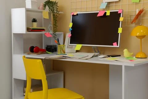 Workplace with computer, sticky notes and shelves in office Stock Photos