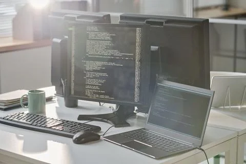 Workplace of computers with codes on screen 写真素材