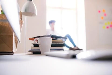 Workplace, desk with computer, coffe mug and books, notes in openspace office Stock Photos