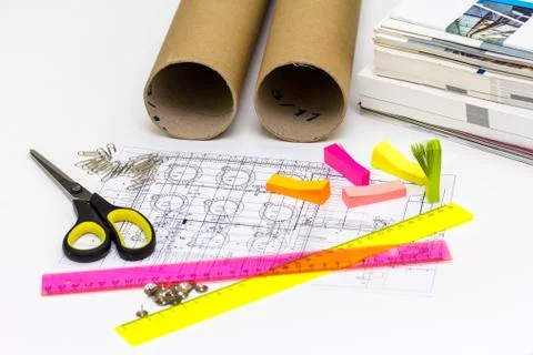Workplace engineer has the blueprints, scissors, rulers, stickers and books. Stock Photos