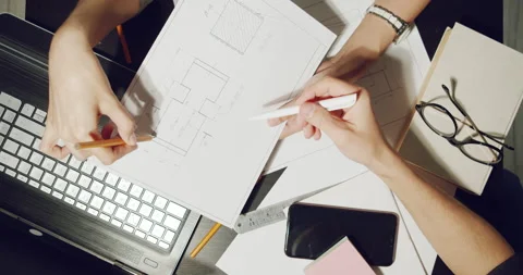 Workplace of engineers discussing project drawings and working on laptop Stock Footage 138528518