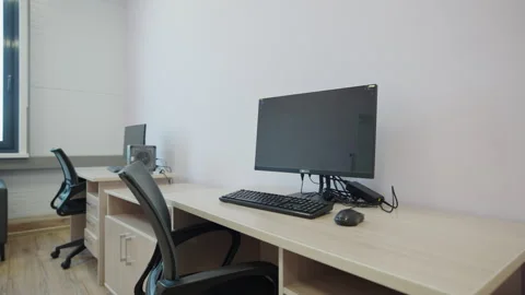 Workplace features wooden desk computer and mesh chair Stock Footage 341861676