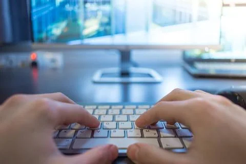 Workplace of a freelancer: Typing hands, screen in the blurry background H... Foto stock