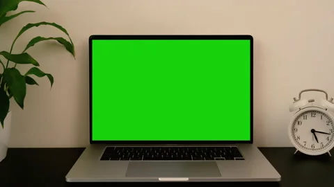 Workplace with green screen laptop computer and clock on black table. Stock Footage 195986523