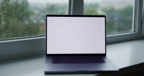 Workplace at home with empty screen mockup laptop computer near window in rain Stock Footage 340227284